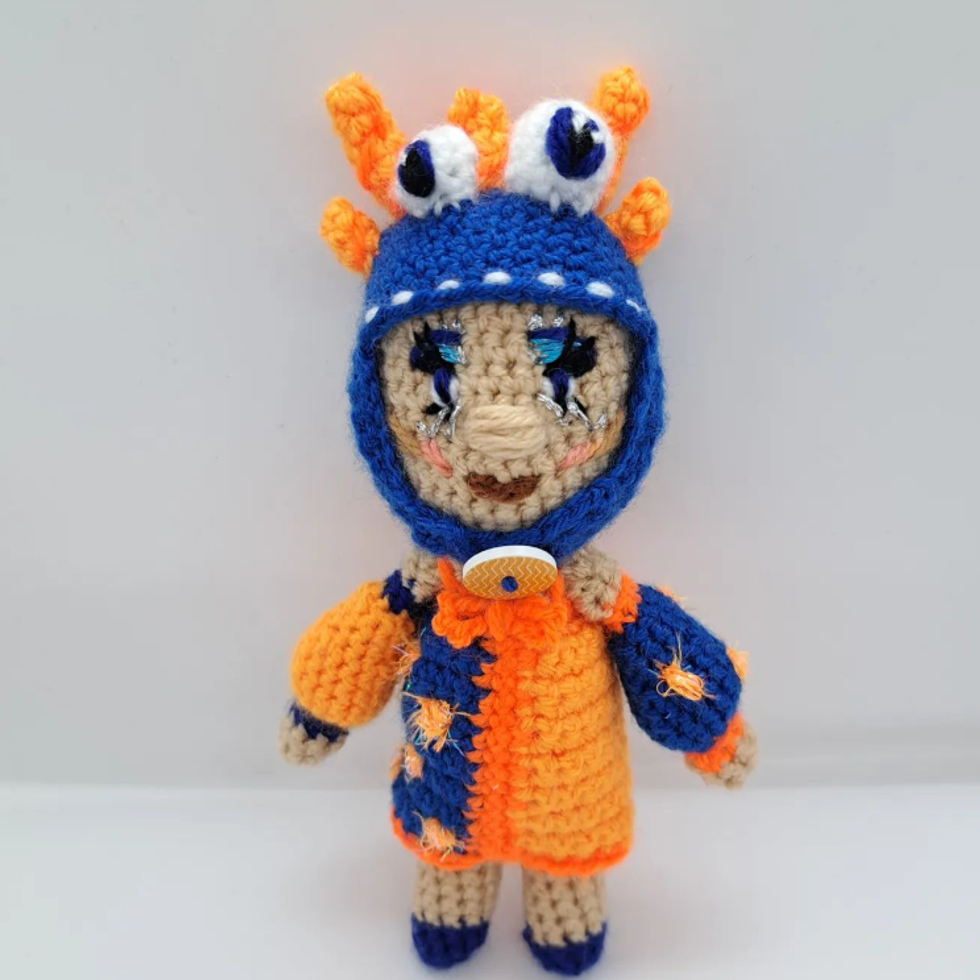 Crocheted doll wearing colourful dress