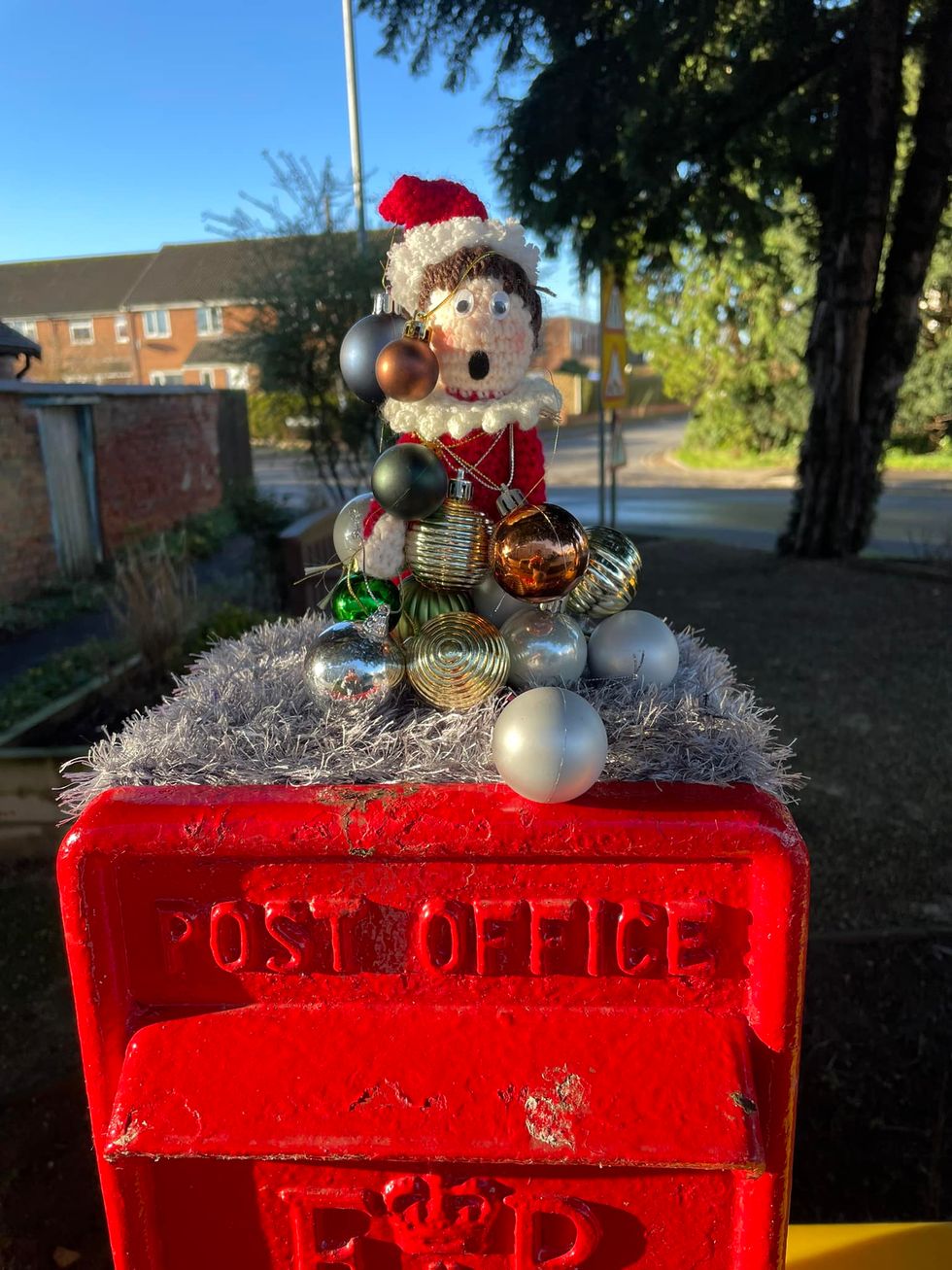 Crocheted elf wrapped in decorations