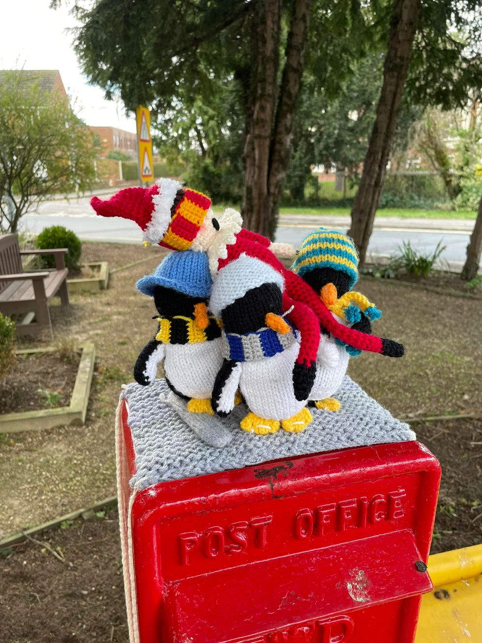 Crocheted penguins carrying crocheted elf