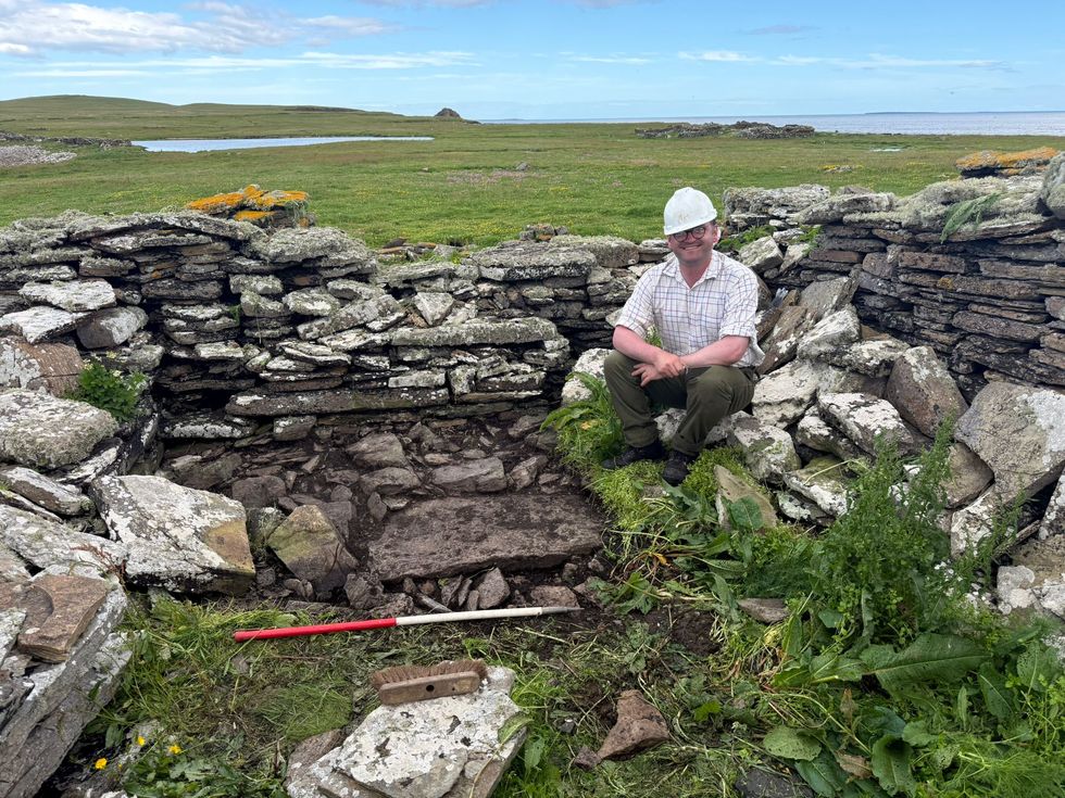 Dan McLean smiling while seated in a ruin