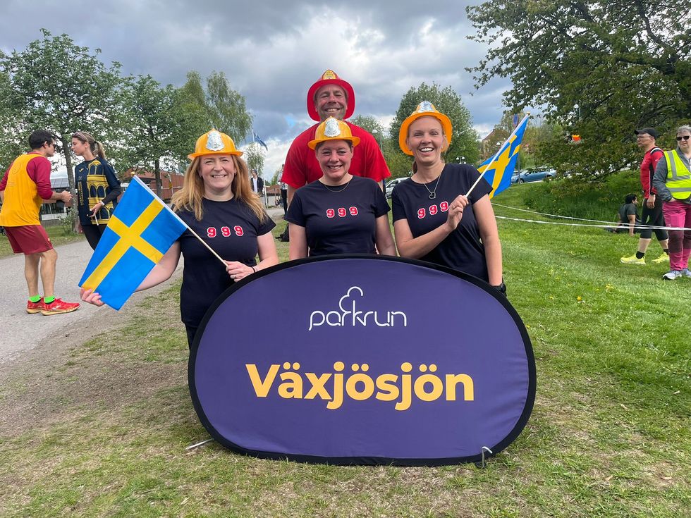 Darren Wood and friends wearing firefighter helmets in Sweden at his 999th parkrun
