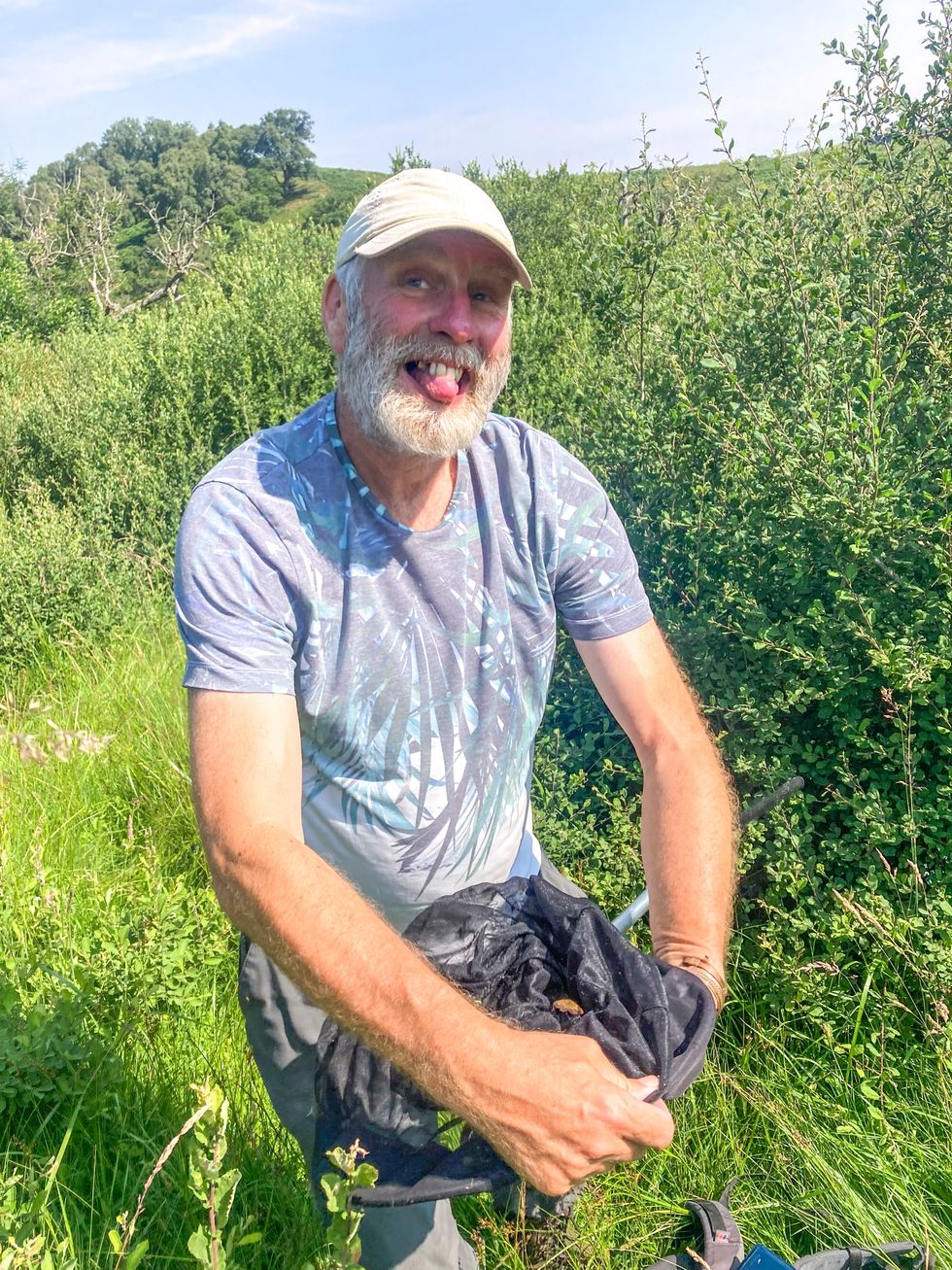 Dave Wainwright holds a net with a moth in it at Wallington