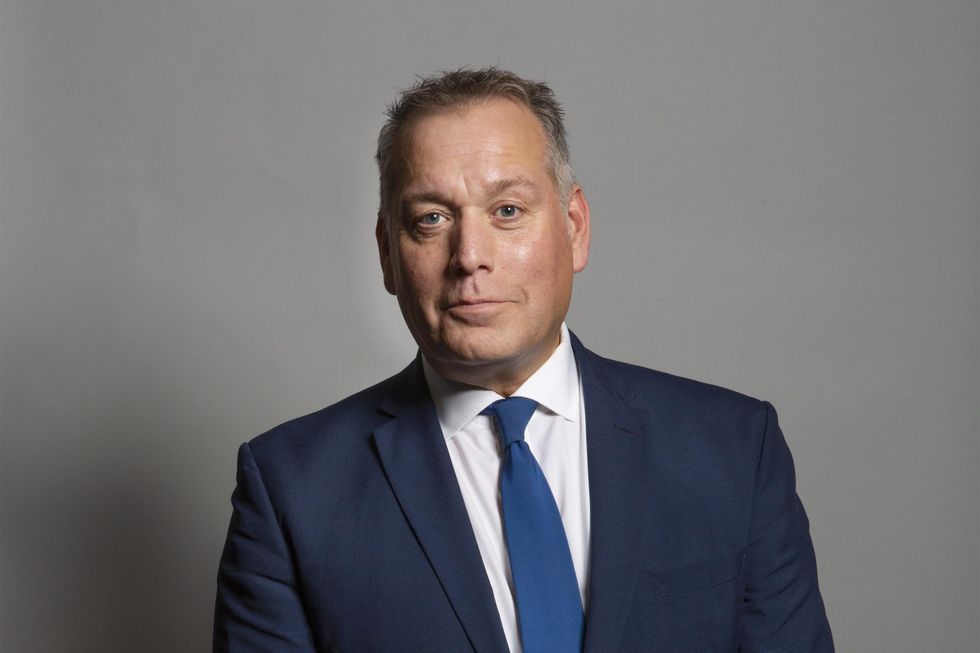 David Warburton, a white man with short grey hair and a blue navy suit.