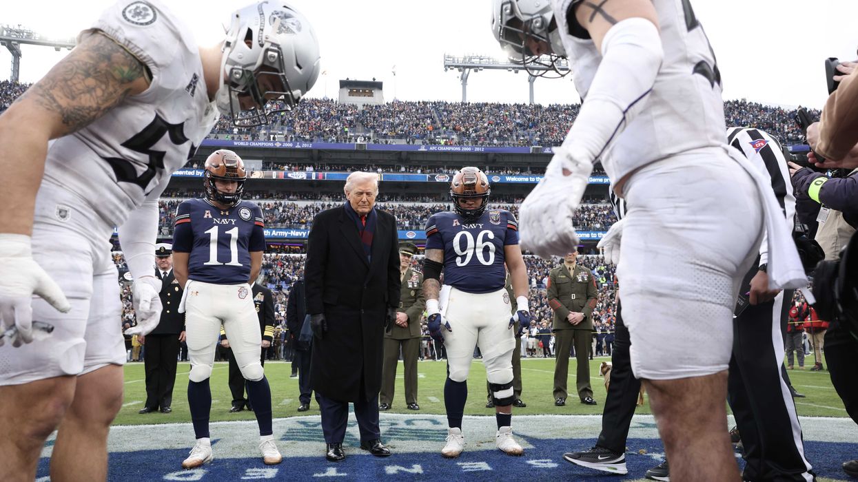 Donald Trump and American football players stare at the ground on the pitch after the US president tossed the coin to start the game.