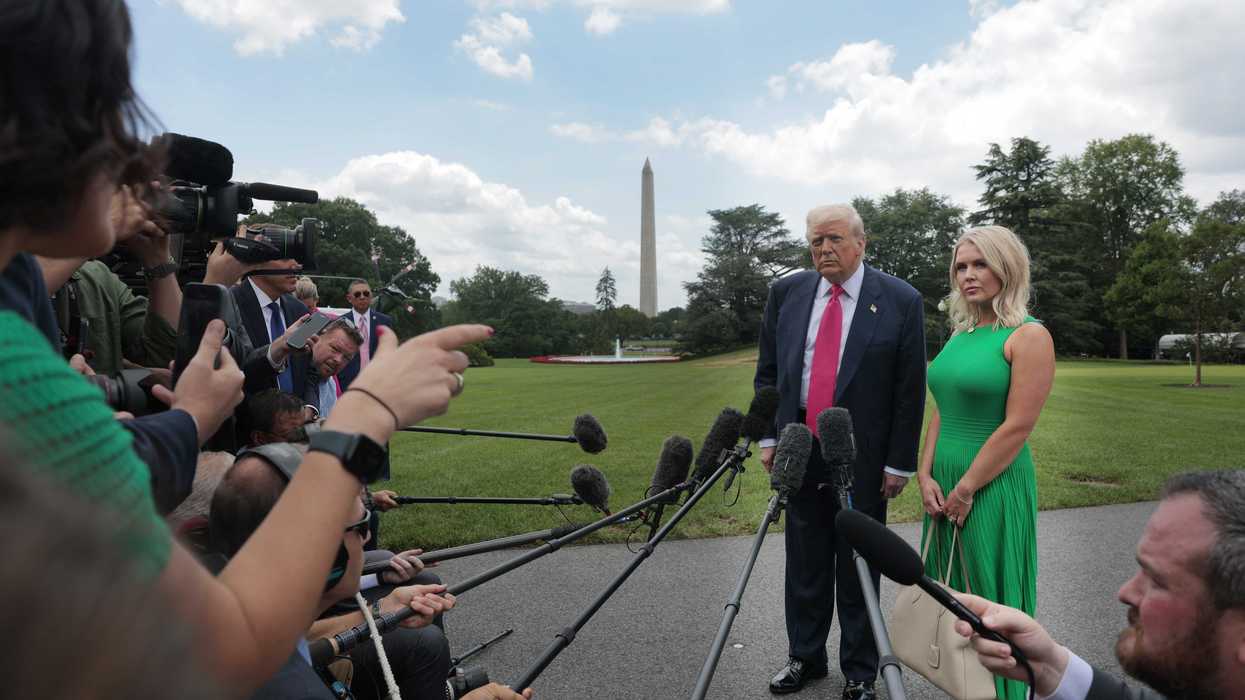 Donald Trump and Karoline Leavitt stand outside the White House taking questions from reporters.