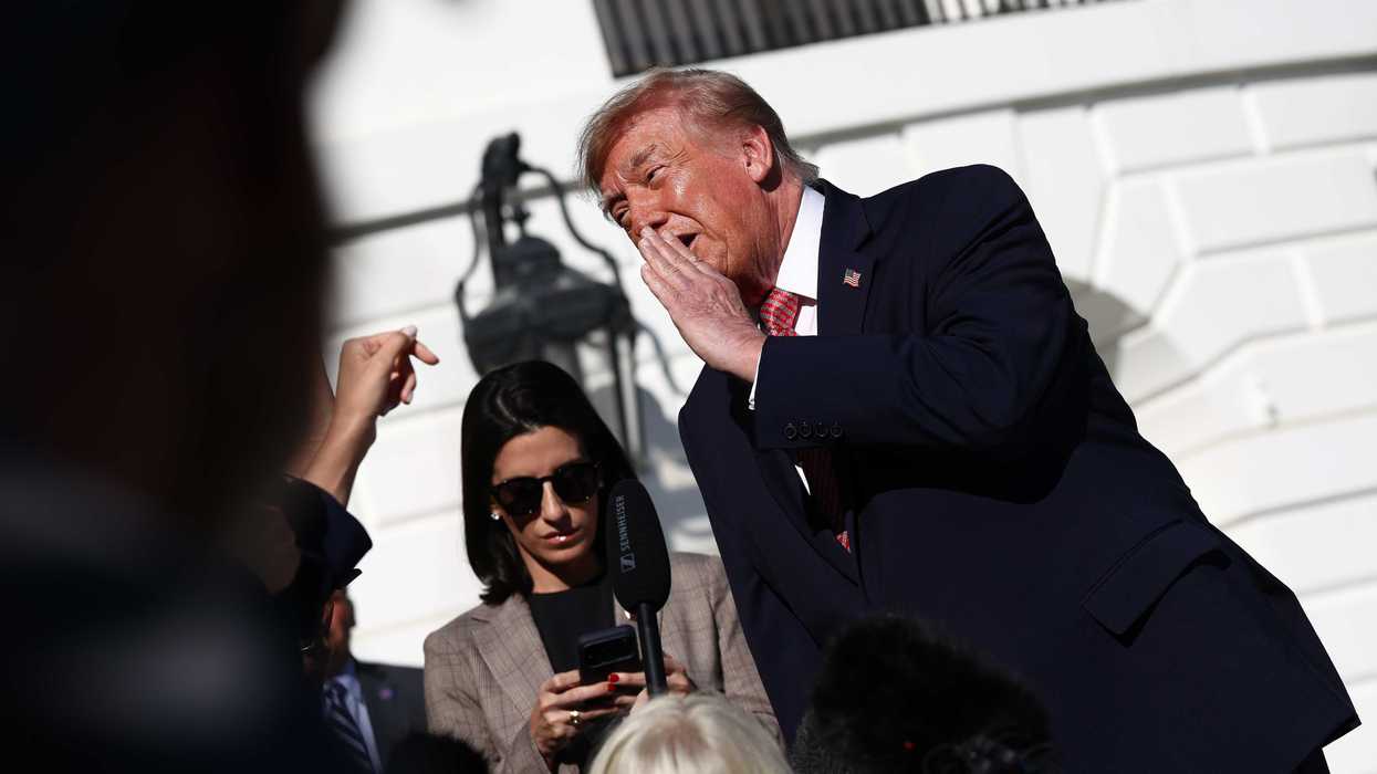 Donald Trump covers one side of his mouth as he talks to reporters outside the White House.