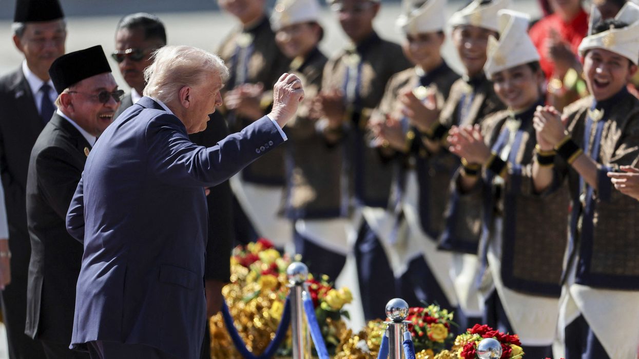 Donald Trump faces Malaysian dancers and dances with them.