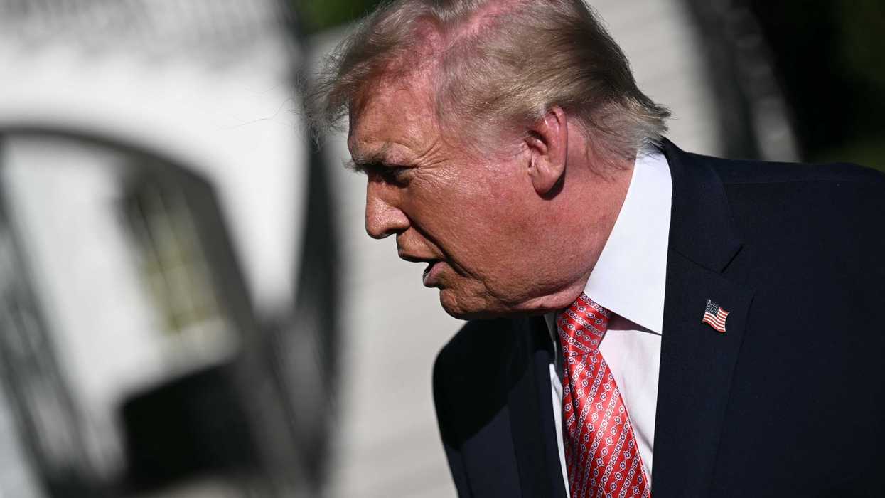Donald Trump, in a black suit, speaks to reporters outside the White House.