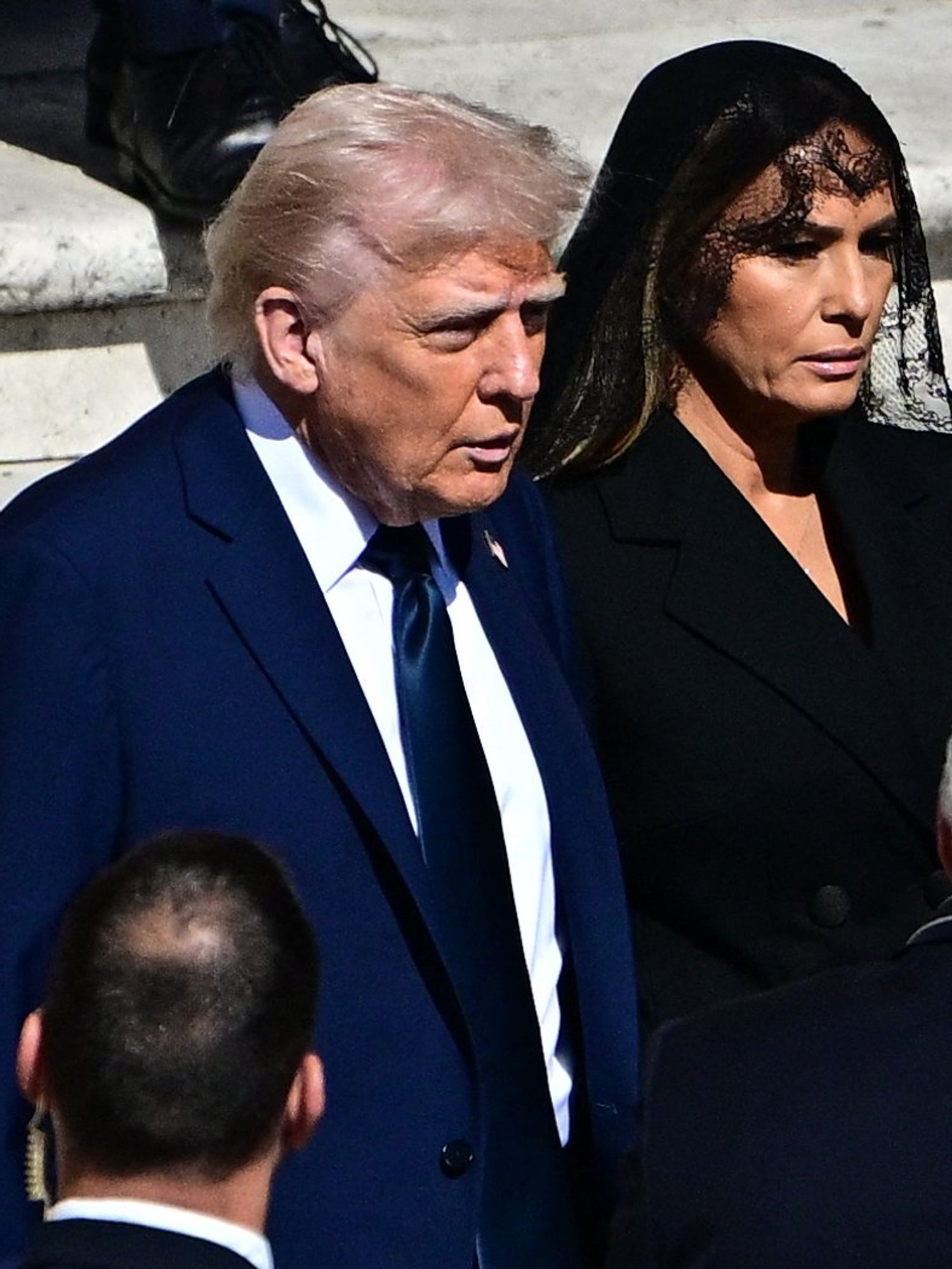Donald Trump in a blue suit and Melania Trump in a black jacket and veil at Pope Francis's funeral.