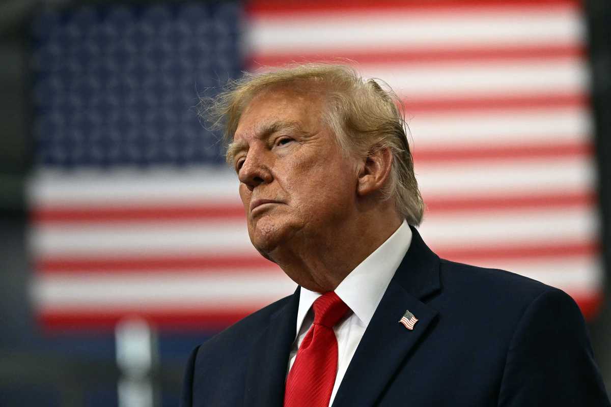 Donald Trump in front of a US flag out of focus in the background.