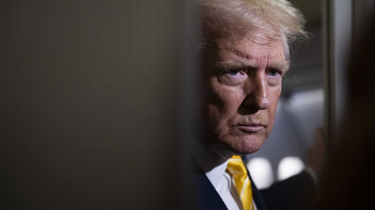 Donald Trump in the doorway inside of Air Force One, speaking to reporters.