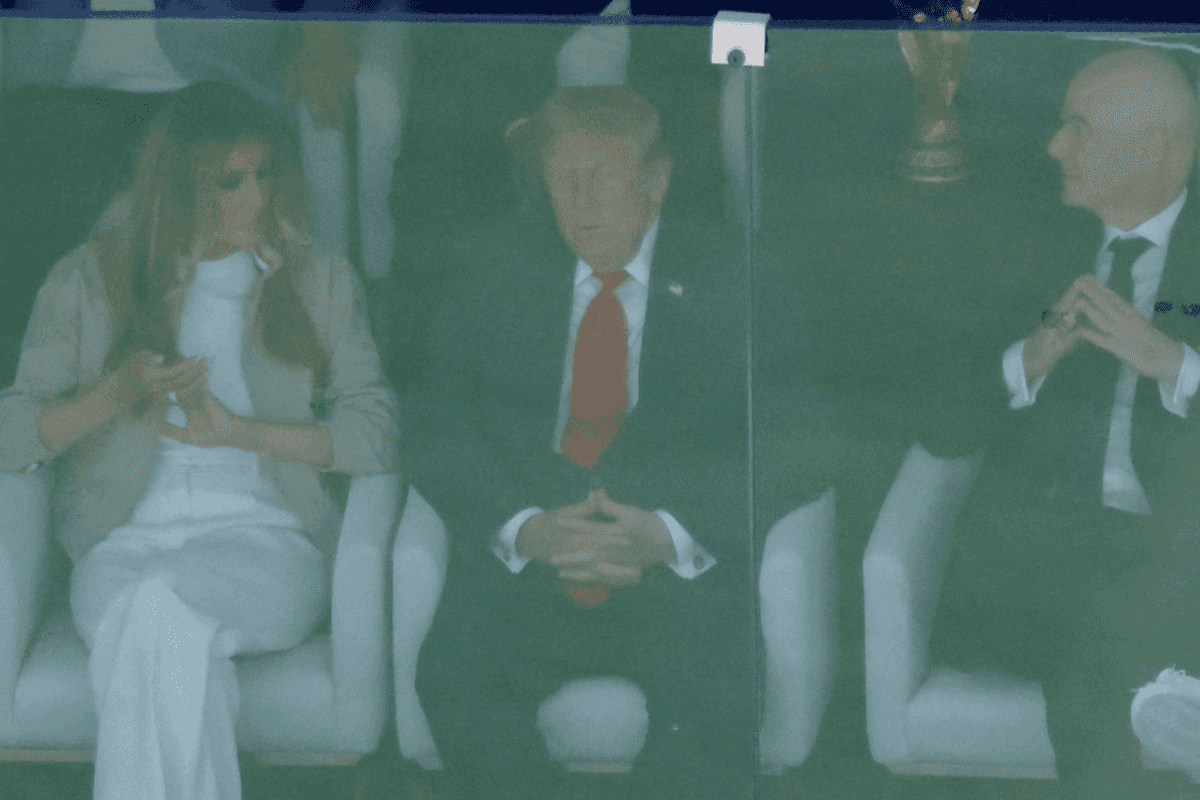Donald Trump in the middle, with Melania Trump on the left and Gianni Infantino on the right, watching the World Cup final behind a glass screen. Trump appears to have his eyes closed.