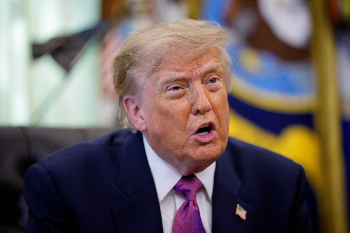 Donald Trump in the Oval Office talking to reporters.