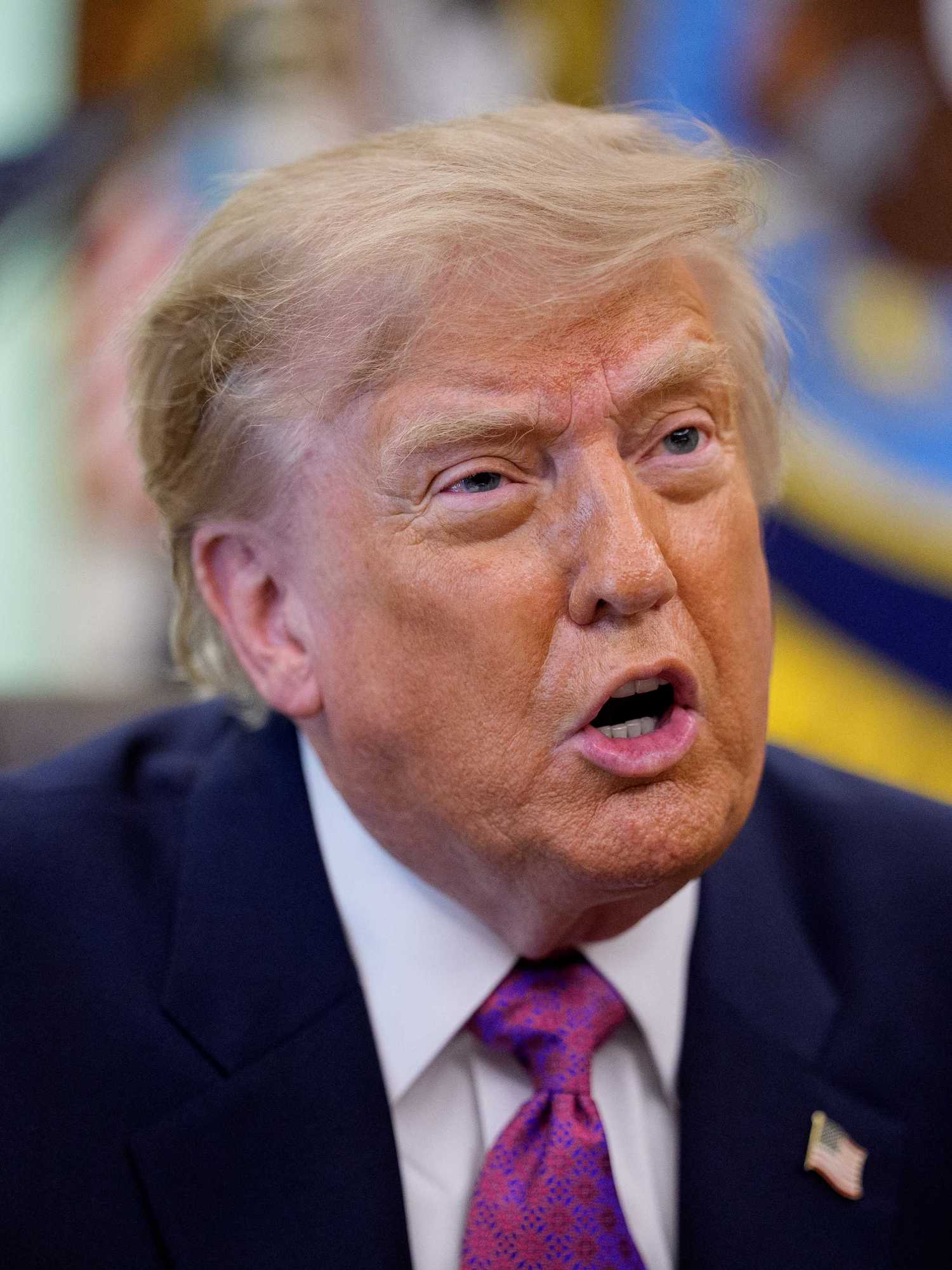 Donald Trump in the Oval Office talking to reporters.