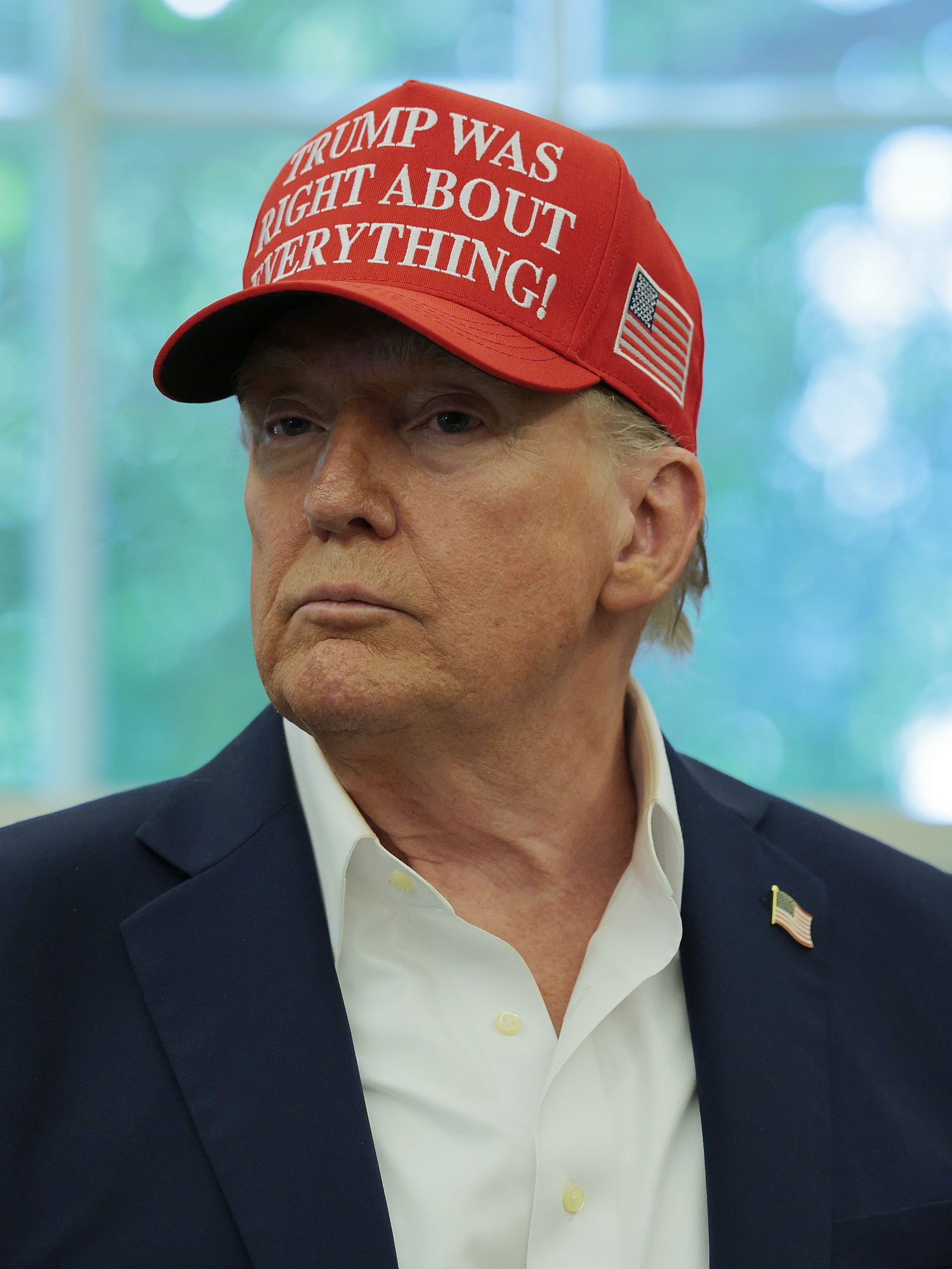 Donald Trump in the Oval Office, wearing a red cap which reads: 'Trump was right about everything!'