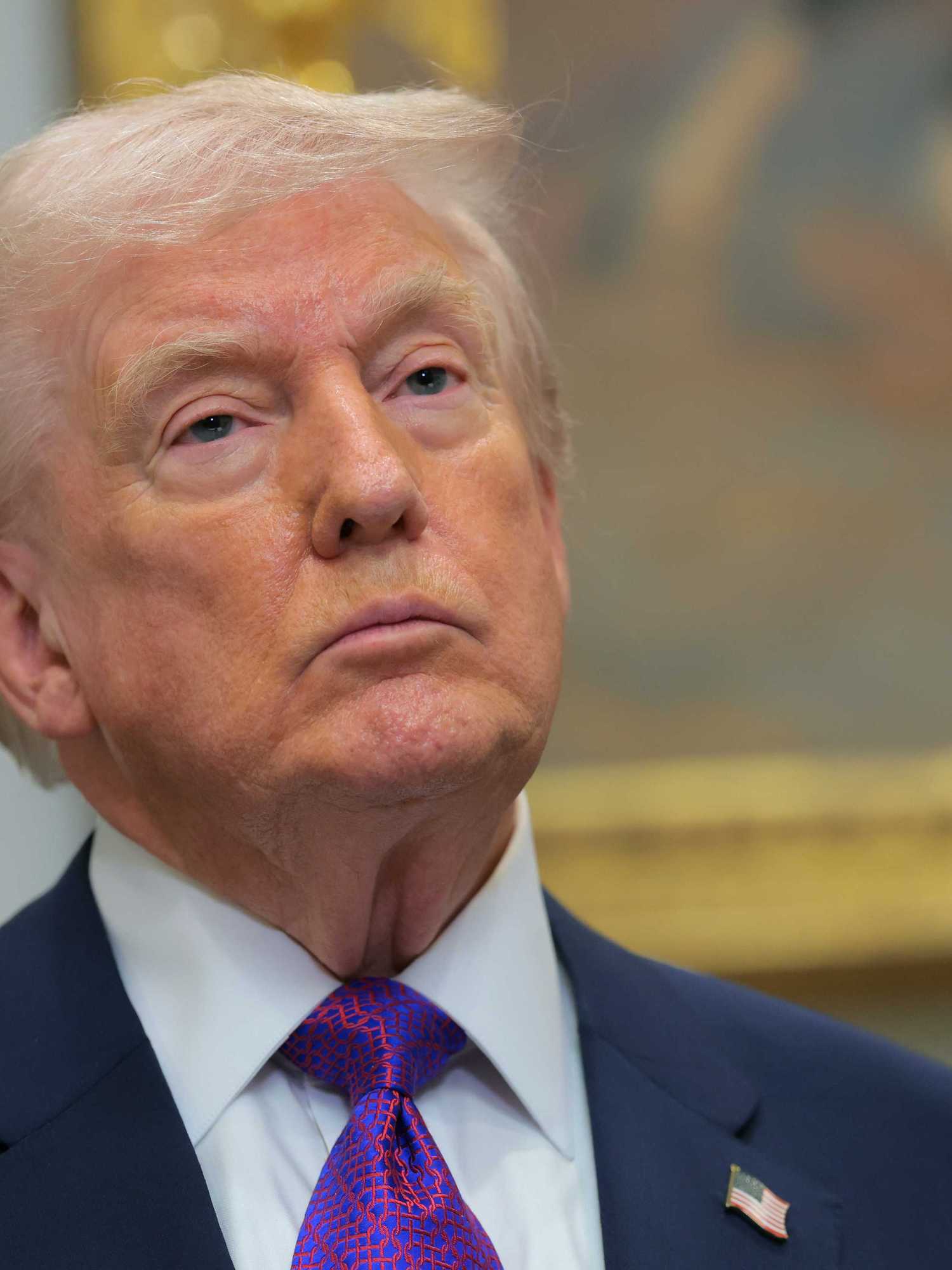 Donald Trump in the Oval Office with a neutral expression on his face.