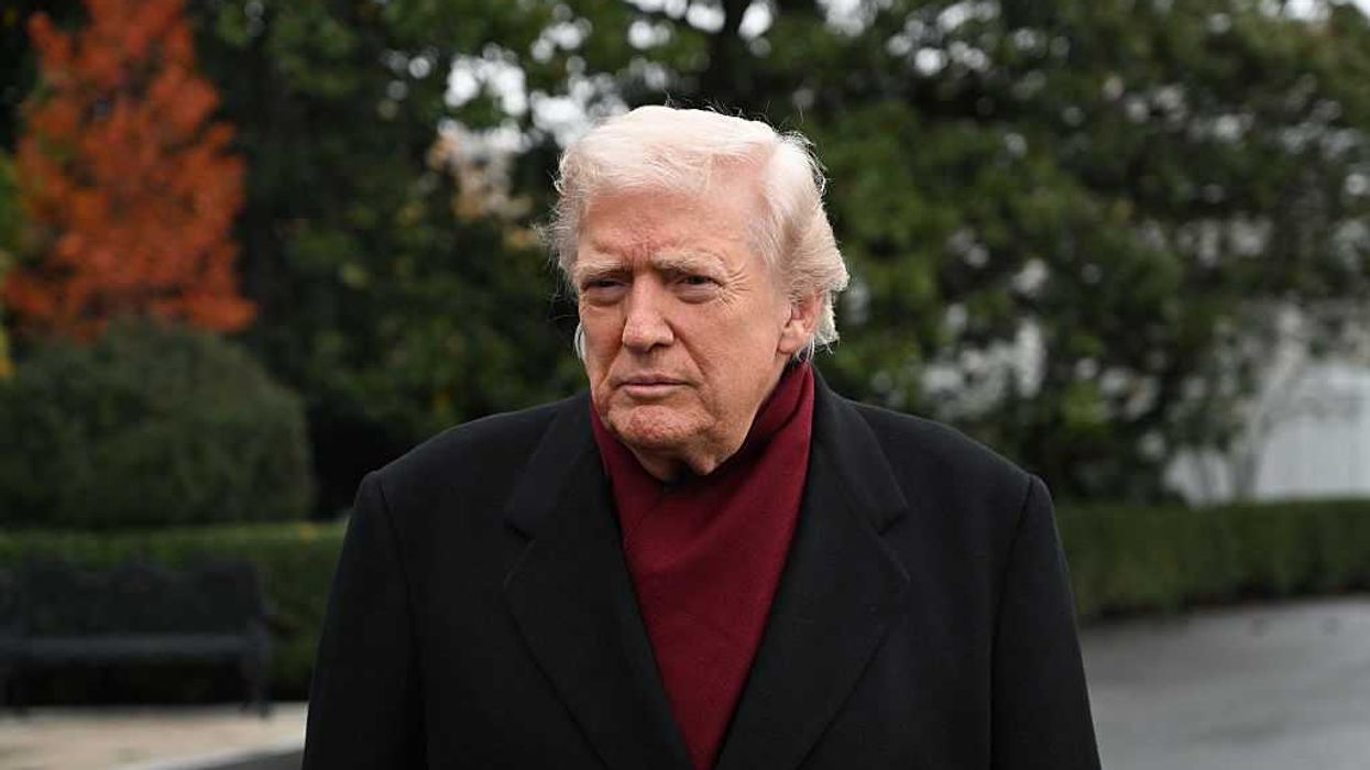 Donald Trump outside the White House, wearing burgundy underneath a black coat.