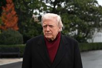 Donald Trump outside the White House, wearing burgundy underneath a black coat.