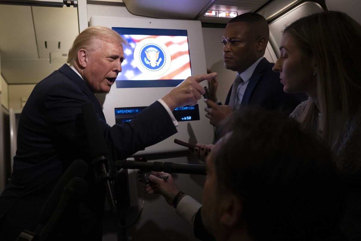 Donald Trump points a finger at a female journalist on board Air Force One.