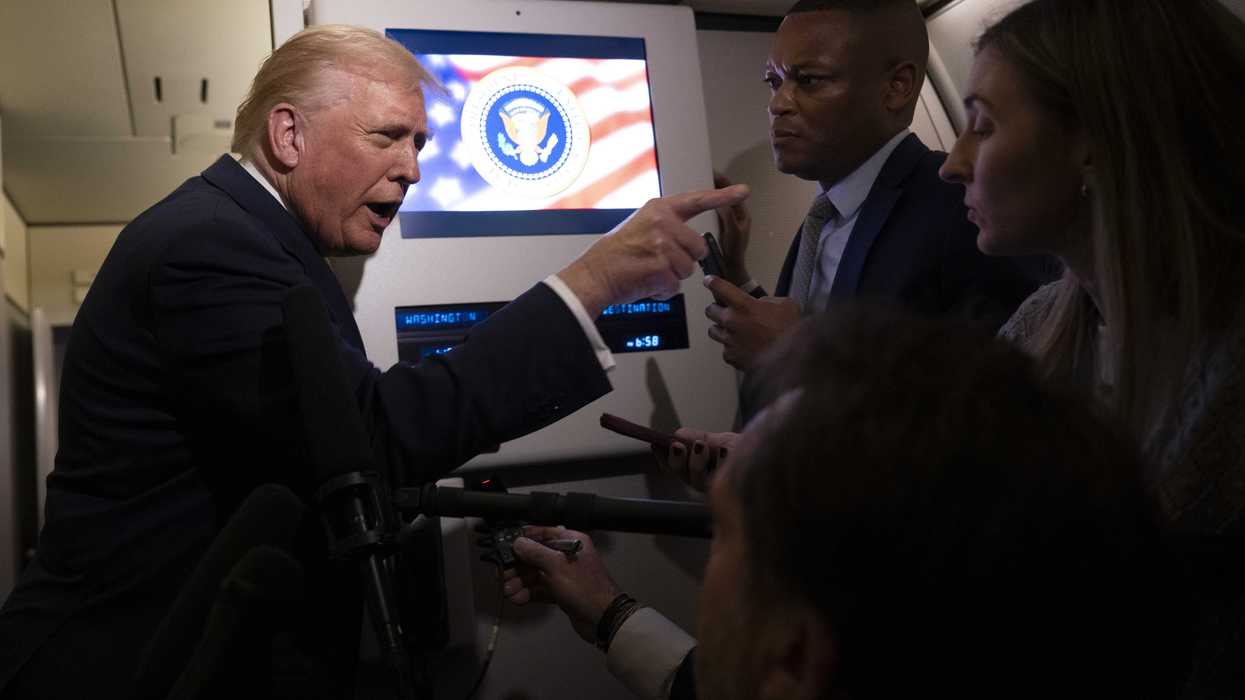Donald Trump points a finger at a female journalist on board Air Force One.