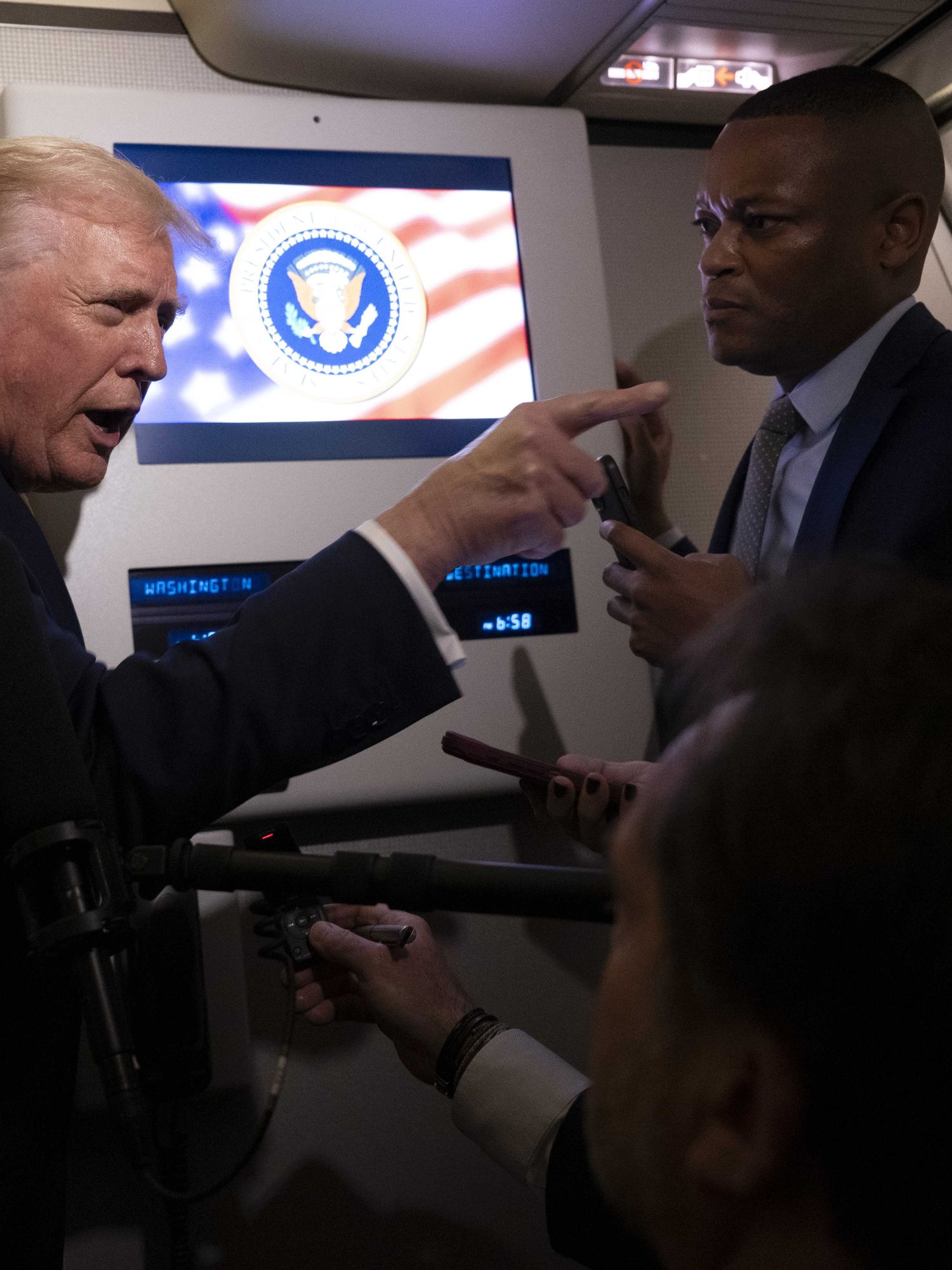Donald Trump points a finger at a female journalist on board Air Force One.