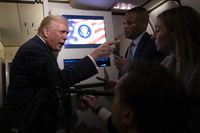 Donald Trump points a finger at a female journalist on board Air Force One.