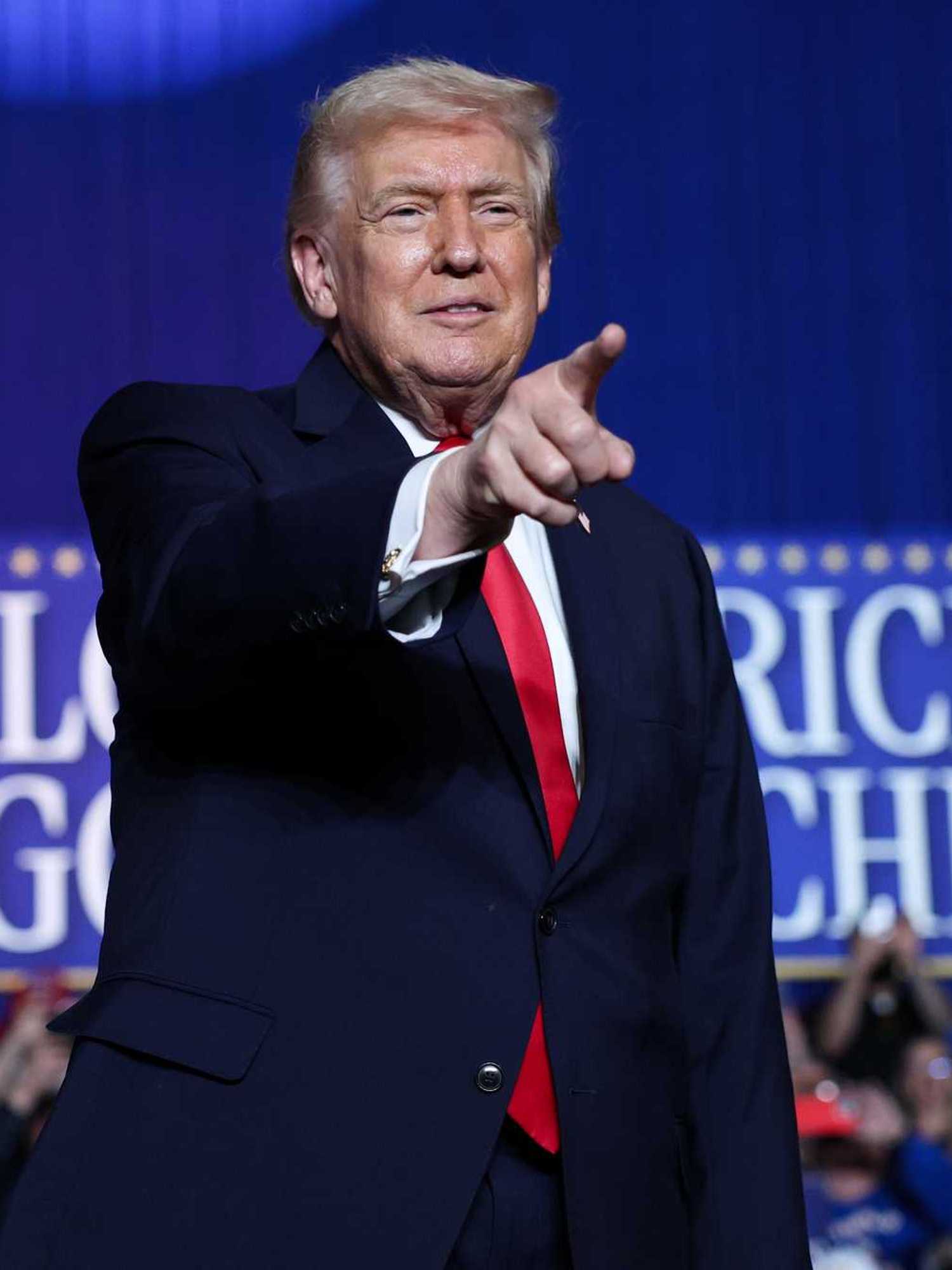 Donald Trump points at someone in the crowd at a rally.