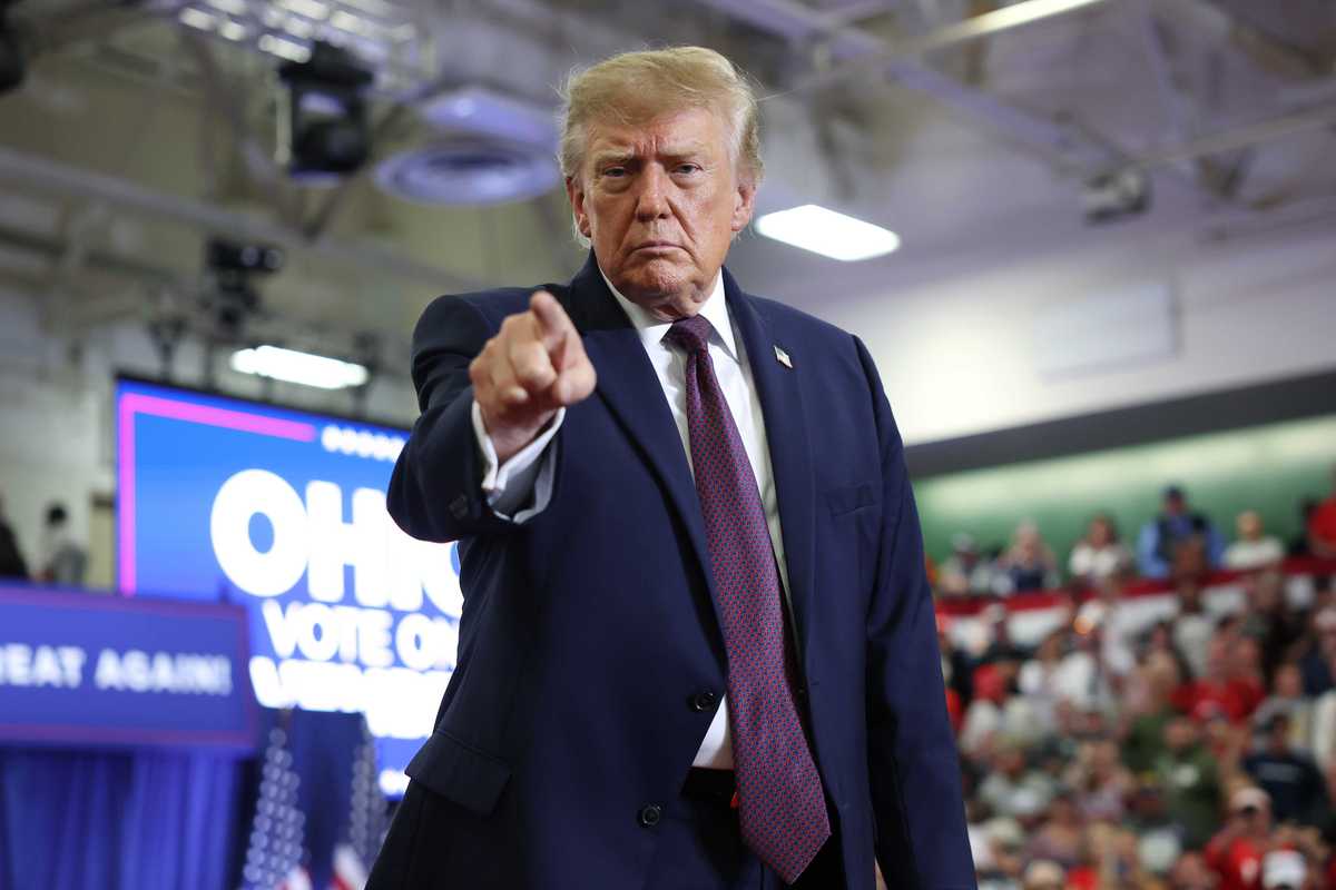 Donald Trump points with his right index finger while standing on stage at a rally in Ohio.