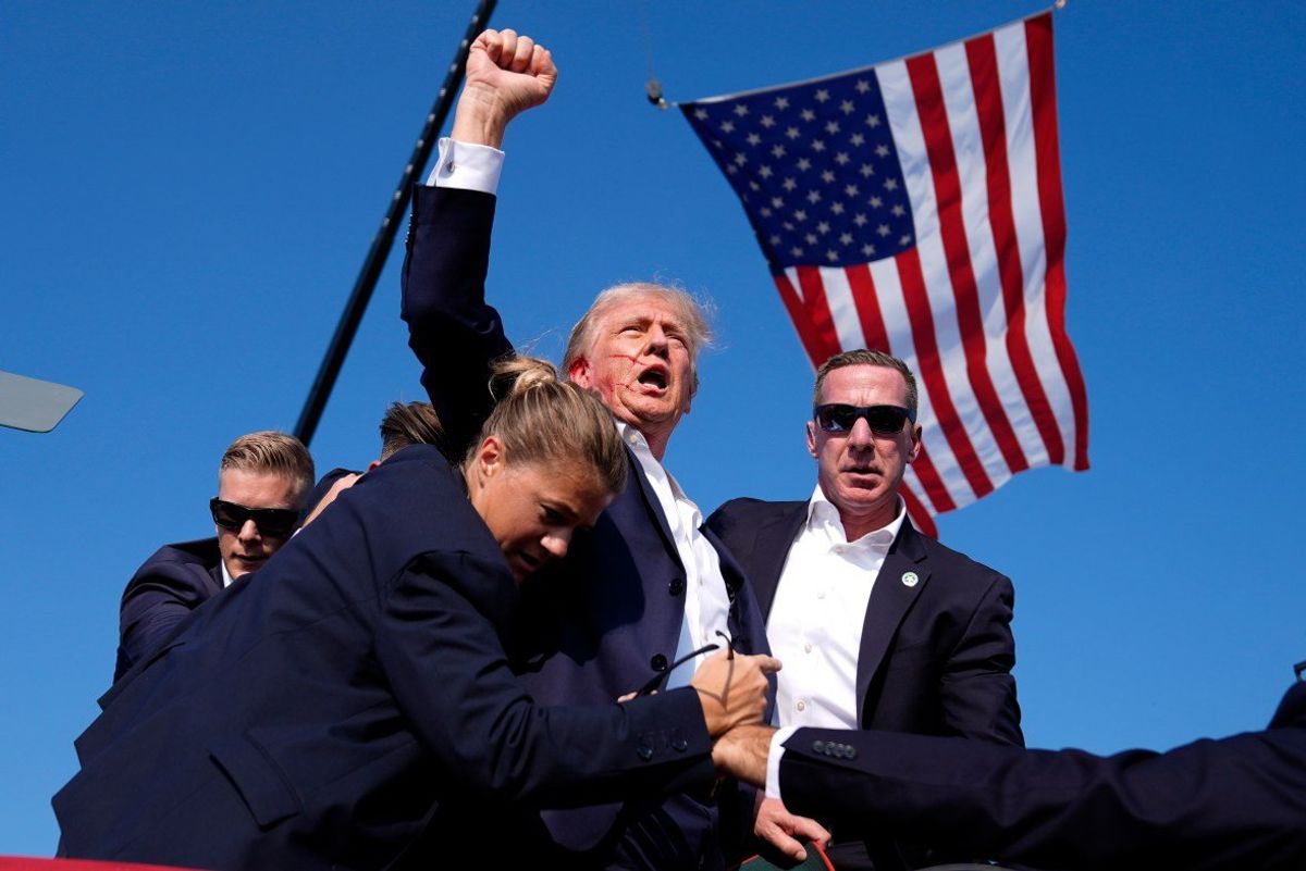 Donald Trump raises his fist beneath the American flag following an attempt on his life in Butler, Pennsylvania in July 2024