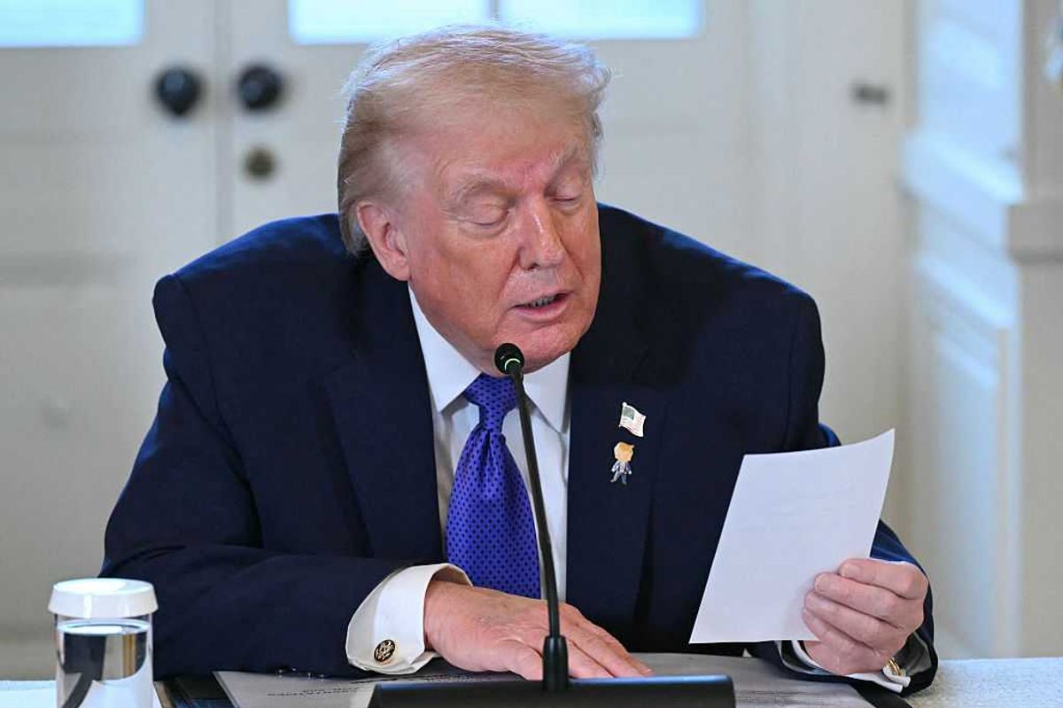 Donald Trump reads from a note on a piece of paper during a White House meeting.