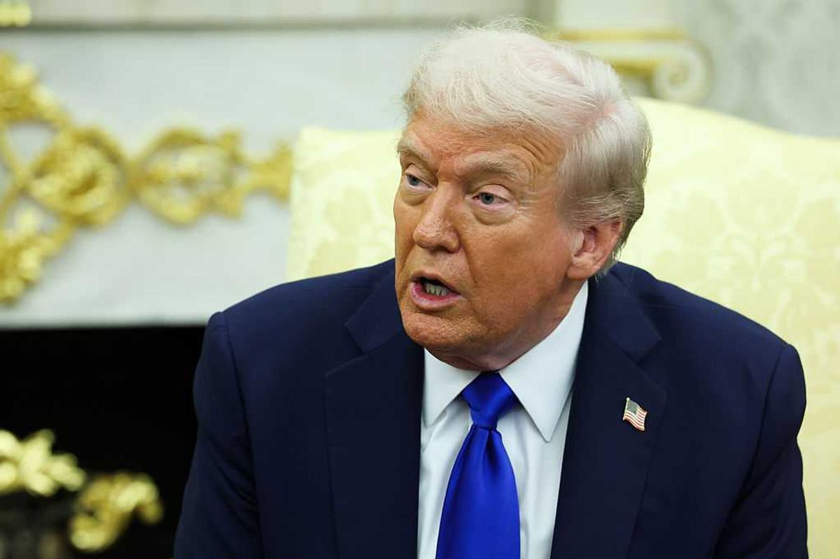 Donald Trump sitting on a cream chair and speaking in the Oval Office.
