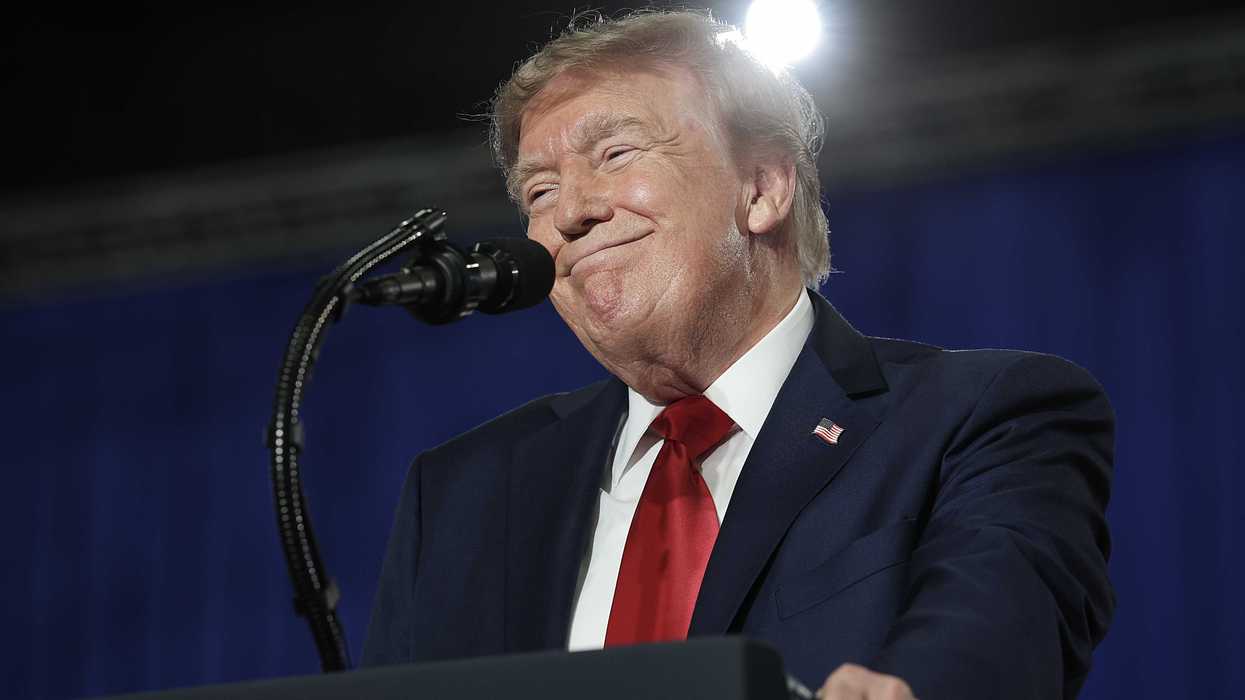 Donald Trump smiles as he stands behind his blue presidential lectern.
