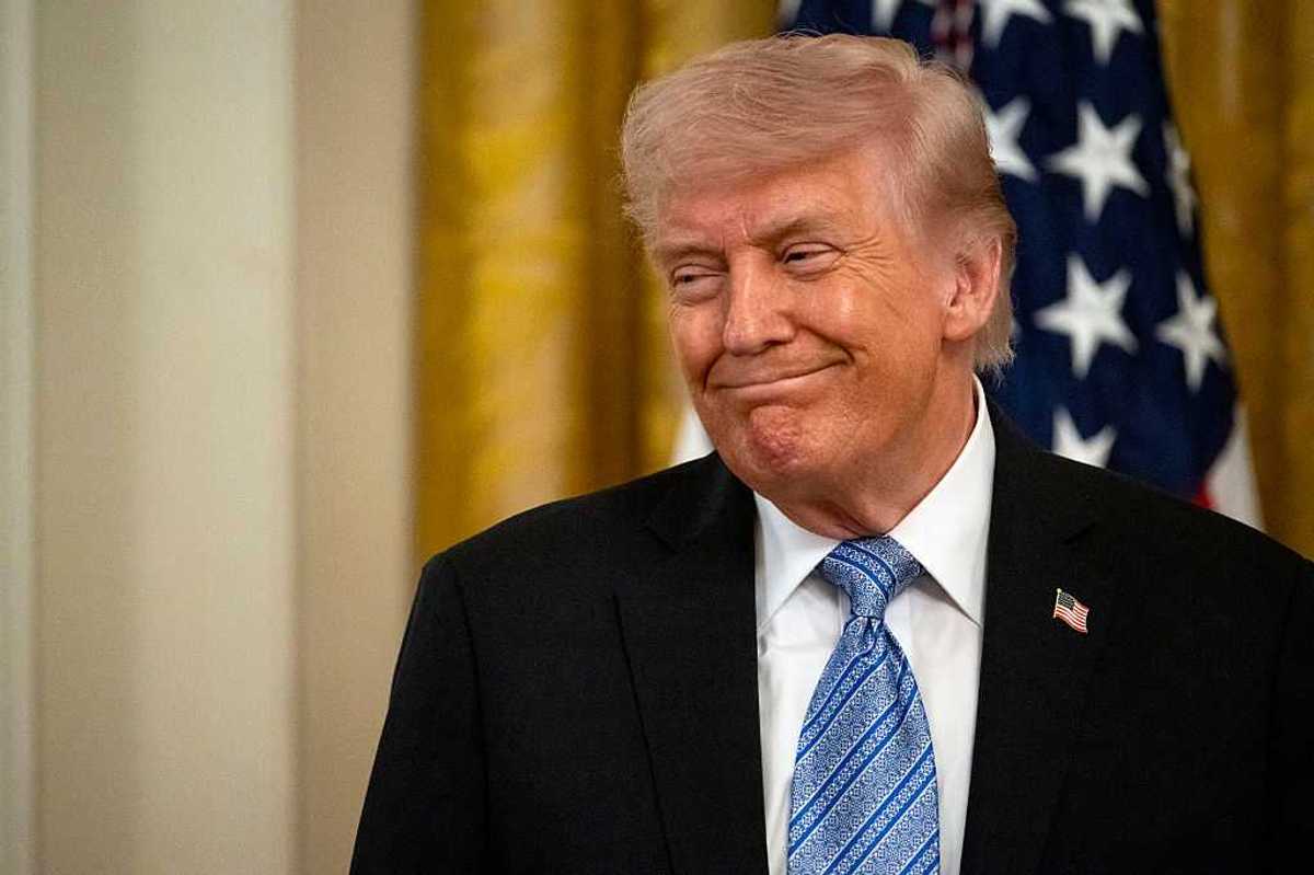Donald Trump smiles at someone off-camera while at a small business summit in the White House.