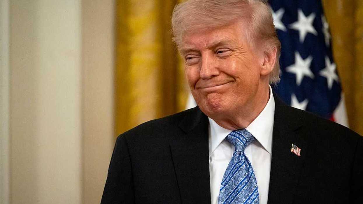 Donald Trump smiles at someone off-camera while at a small business summit in the White House.