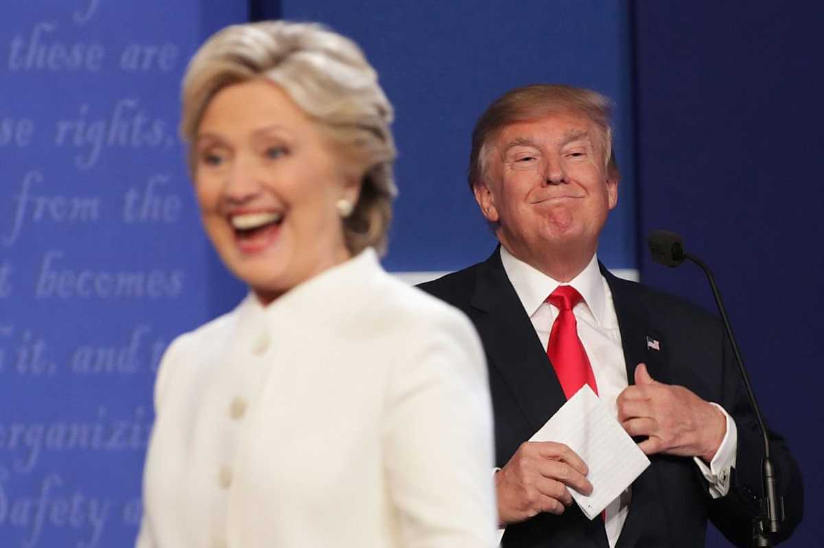 Donald Trump smiles behind Hillary Clinton following a US presidential debate in Las Vegas on 19 October, 2016