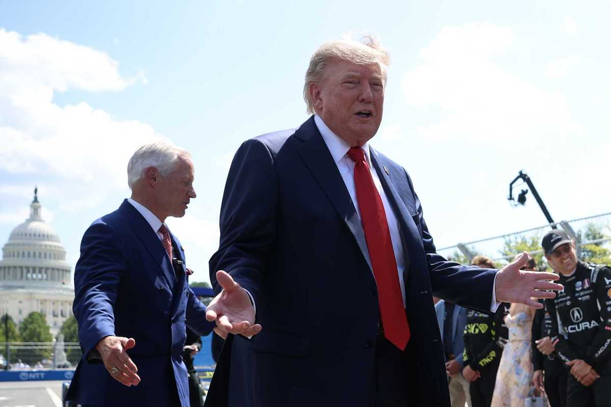 Donald Trump smiles with open hands at drivers in Washington, D.C., for the Freedom 250 Grand Prix.