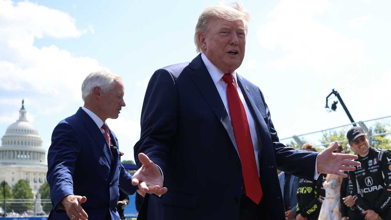Donald Trump smiles with open hands at drivers in Washington, D.C., for the Freedom 250 Grand Prix.