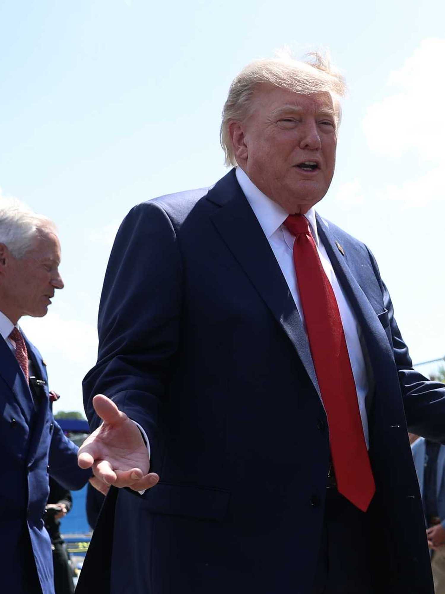 Donald Trump smiles with open hands at drivers in Washington, D.C., for the Freedom 250 Grand Prix.