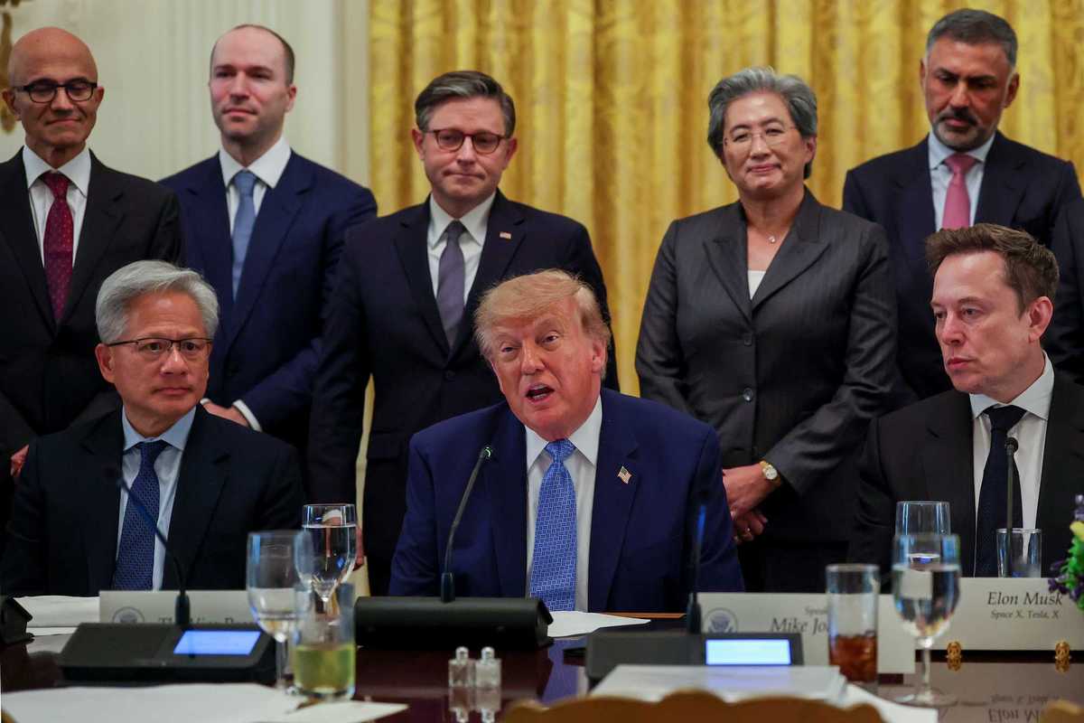 Donald Trump speaking to reporters while sat at a table, surrounded by tech CEOs.