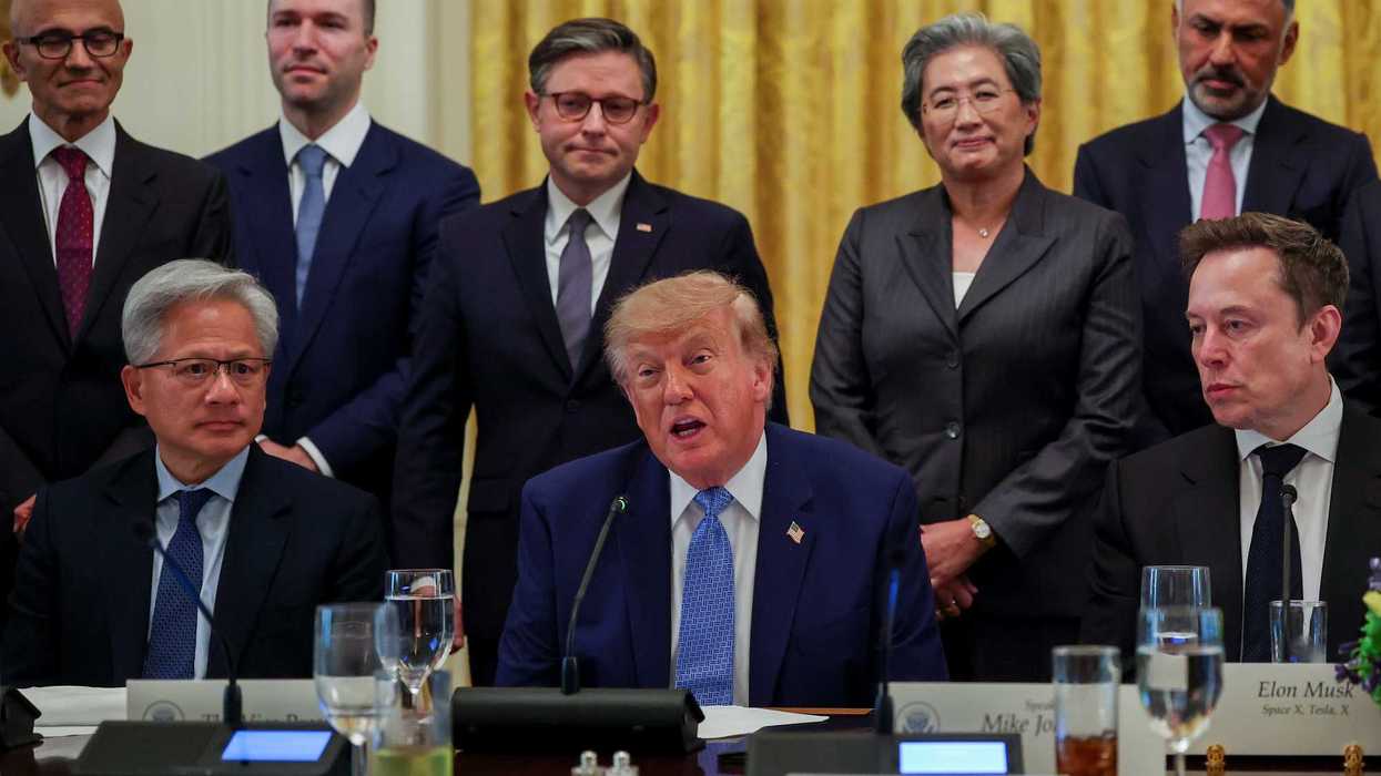 Donald Trump speaking to reporters while sat at a table, surrounded by tech CEOs.