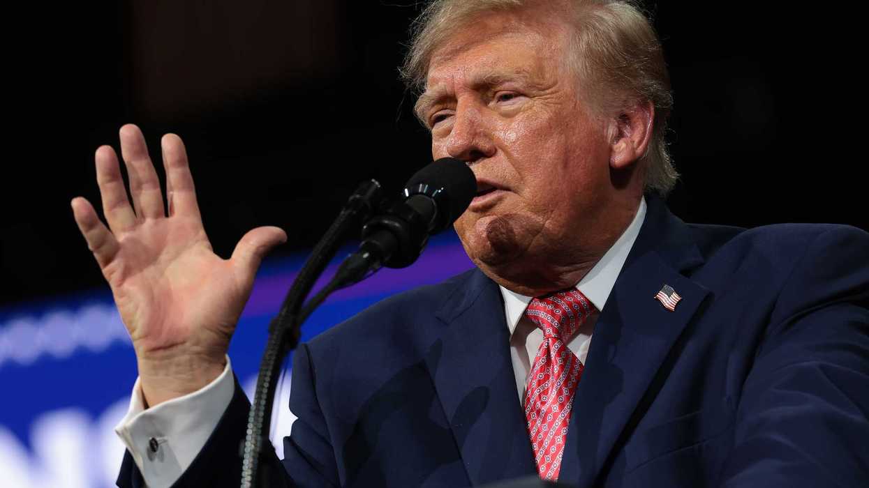Donald Trump speaks behind a lectern and microphone at a rally in Kansas.