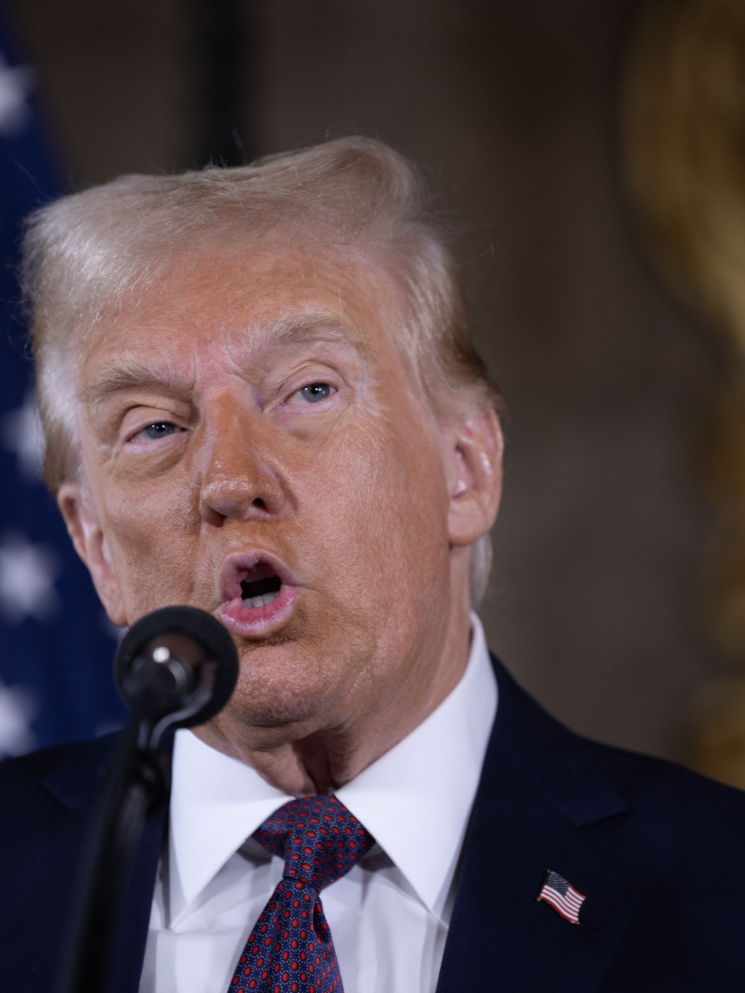 Donald Trump speaks into a microphone at a Mar-a-Lago press conference.