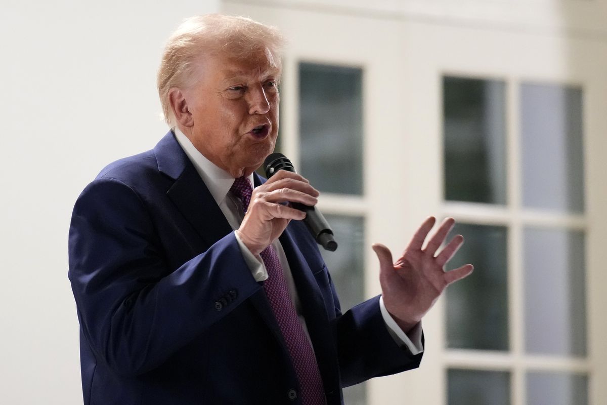 Donald Trump speaks into a microphone on the White House porch overlooking the Rose Garden.