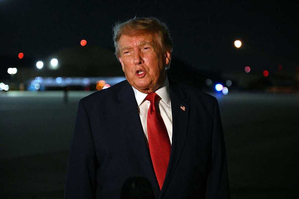 Donald Trump speaks to reporters at night at Joint Base Andrews, Maryland.