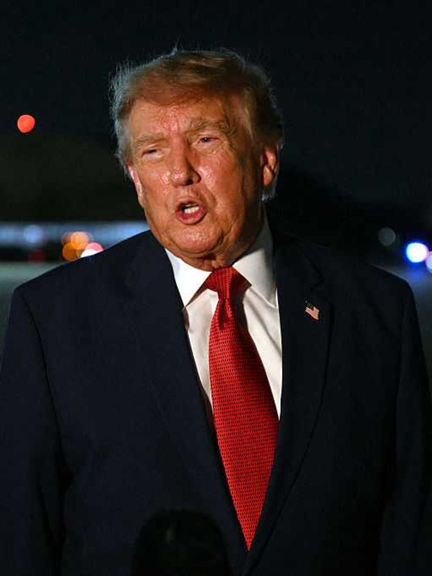 Donald Trump speaks to reporters at night at Joint Base Andrews, Maryland.