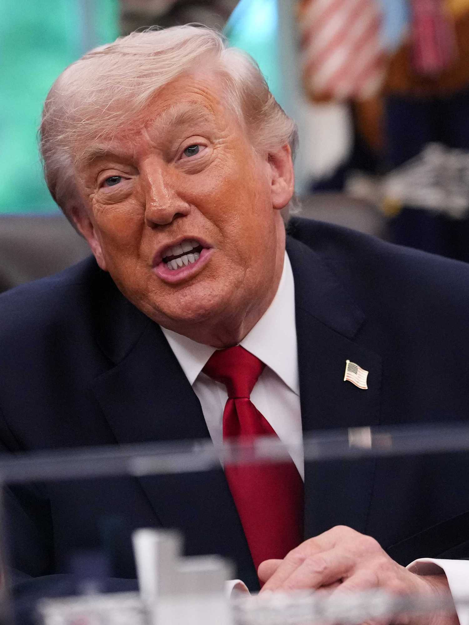 Donald Trump speaks to reporters behind the Resolute Desk in the Oval Office.