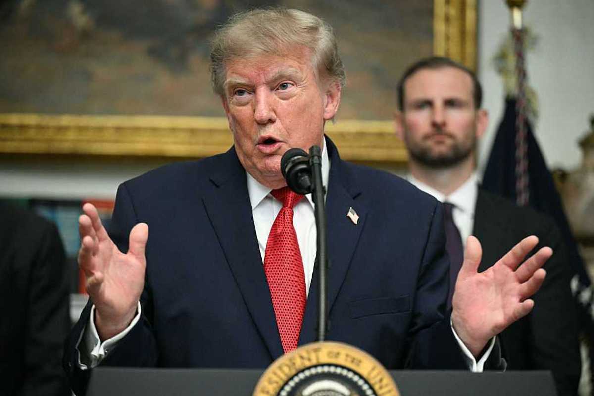 Donald Trump speaks to reporters in the White House behind his presidential lecter