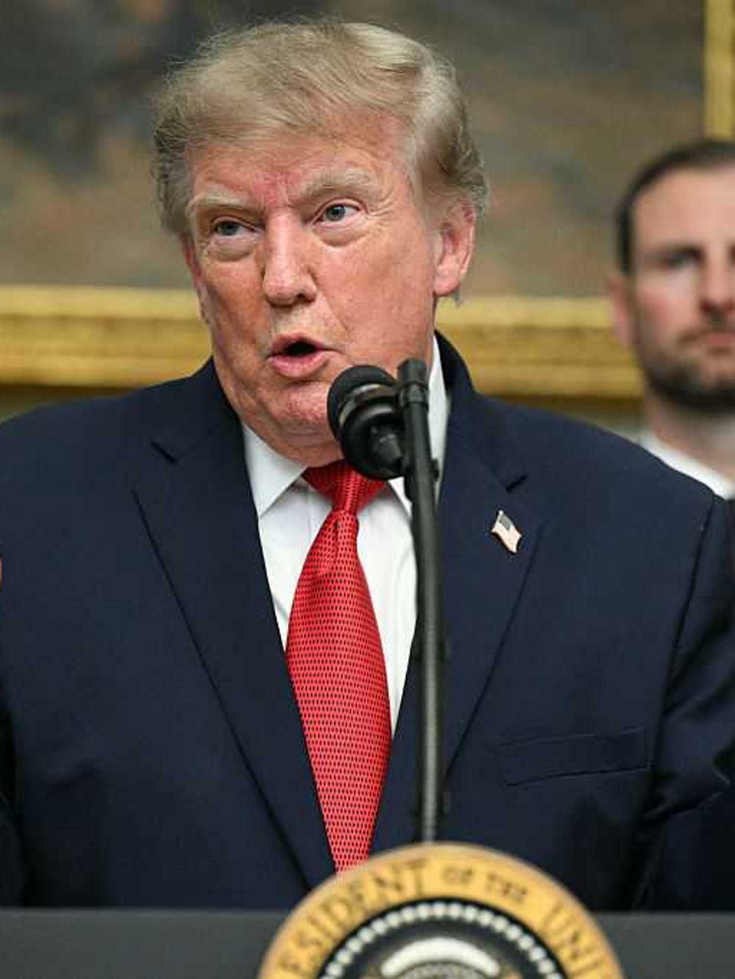 Donald Trump speaks to reporters in the White House behind his presidential lecter