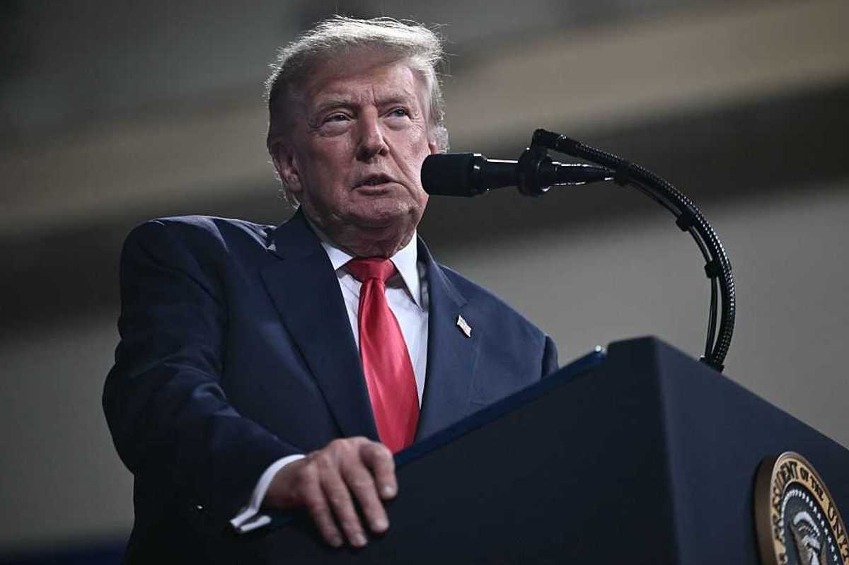 Donald Trump standing behind the presidential lectern and speaking into a microphone during a rally in Georgia.