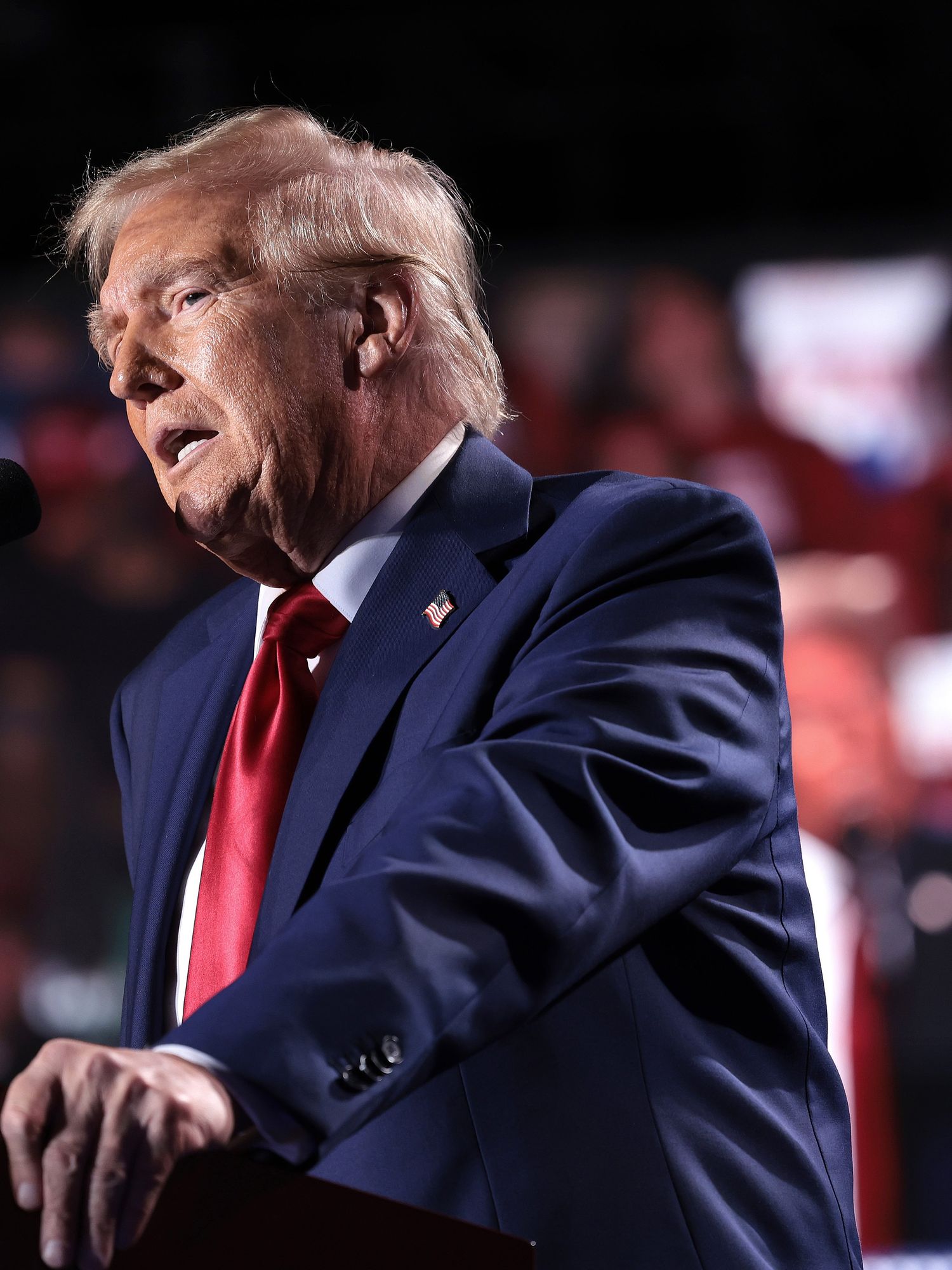 Donald Trump stands behind a wooden lectern and delivers a speech at his rally in Michigan.